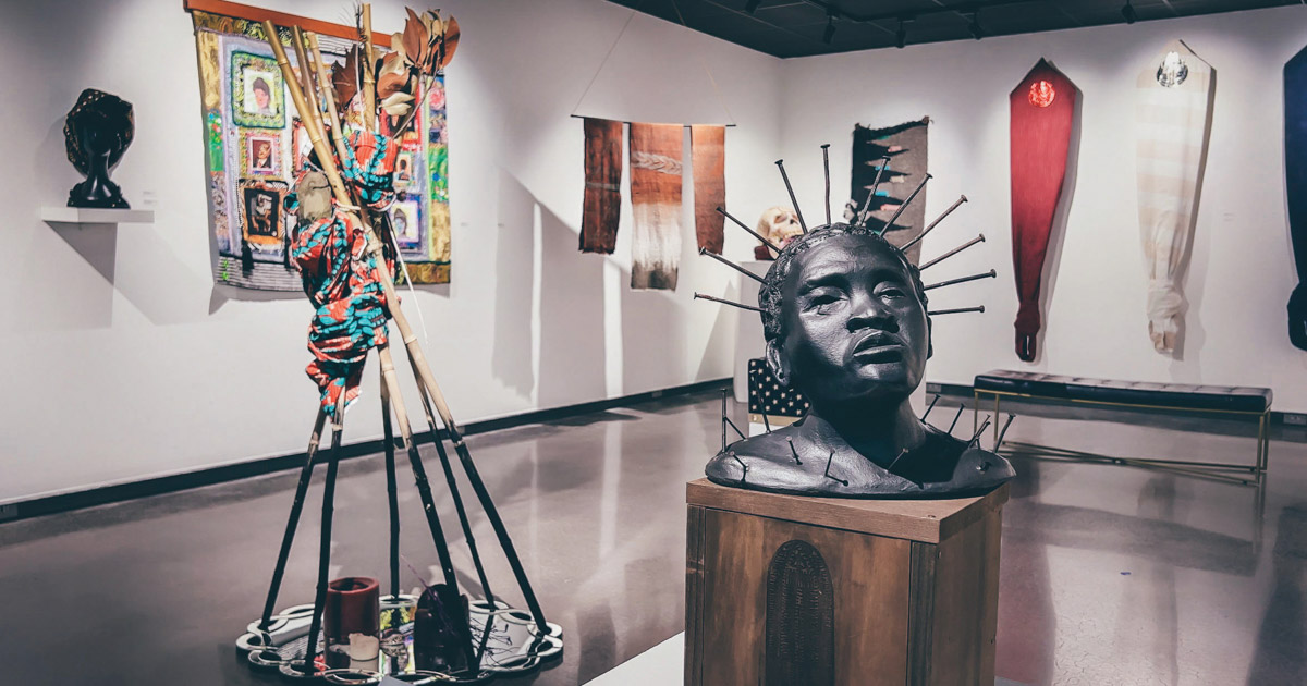 A photo of the Crafting Blackness exhibit, including sculptures and works of art hanging on the wall.