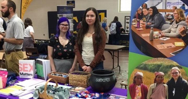 two women stand behind a table