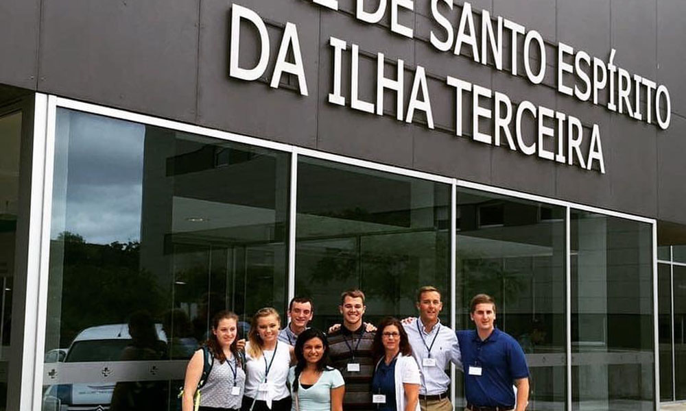 A group of college students pose in front of the "Hospital de Santo Espirito da Ilha Terceira."