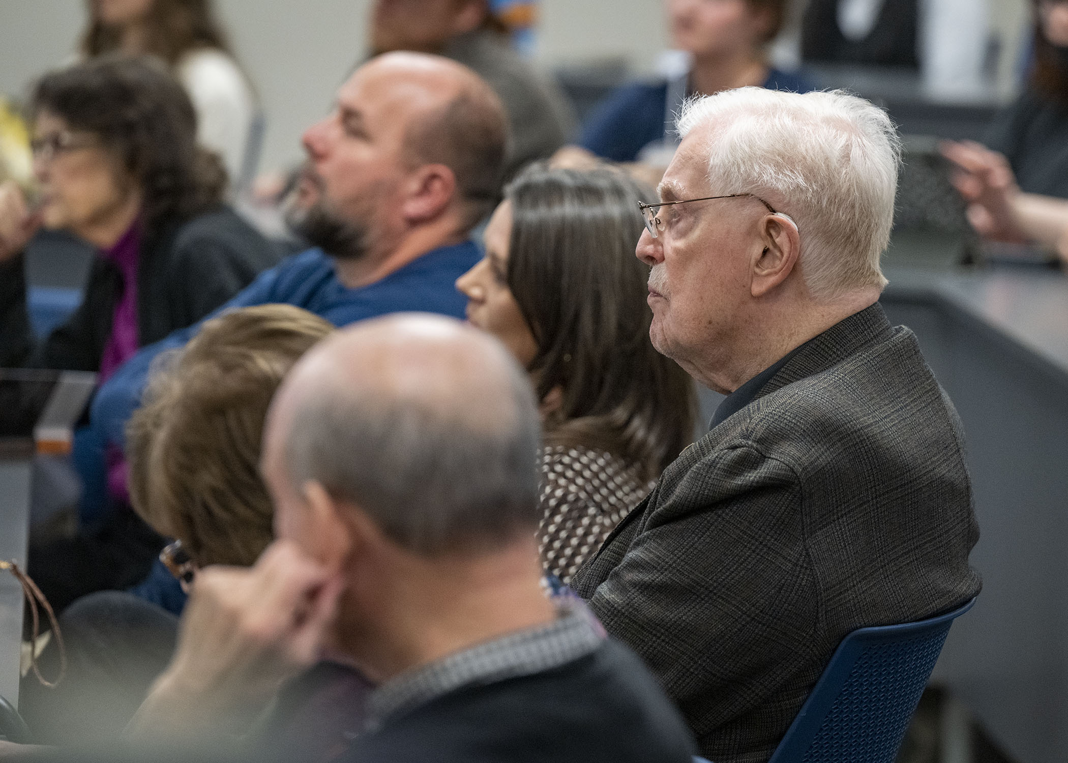 Dr. Bert C. Bach and other attendees listen to the visiting writers read their poetry. 