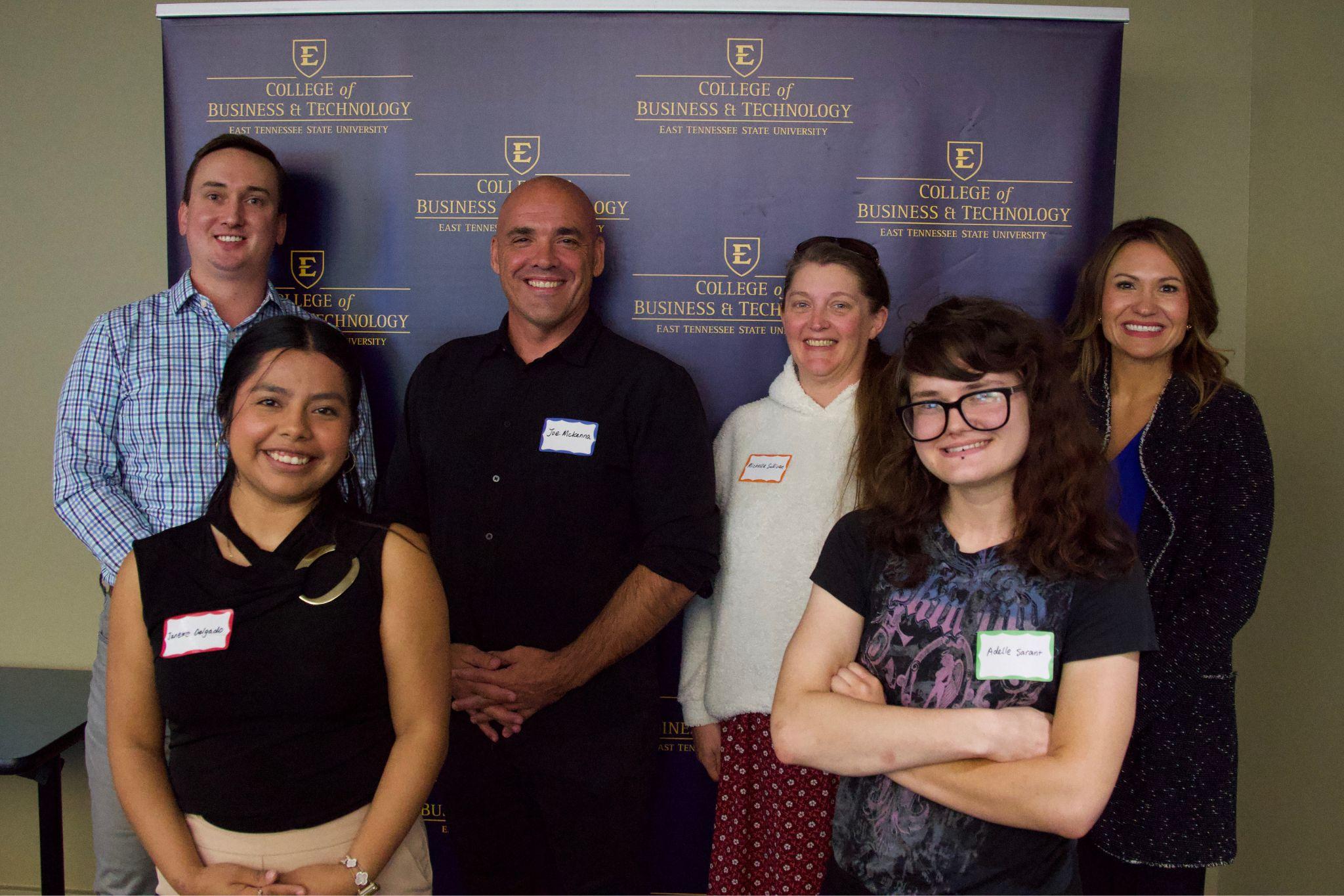 Six ETSU CBAT members pose in front of a College of Business and Technology backdrop.