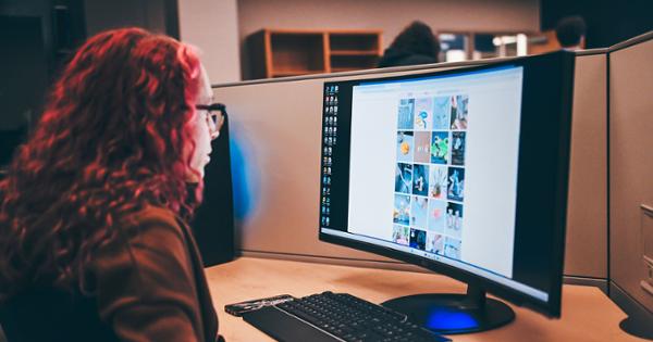 An ETSU student in a computer lab sitting at a desk and looking at the content of a website on a computer