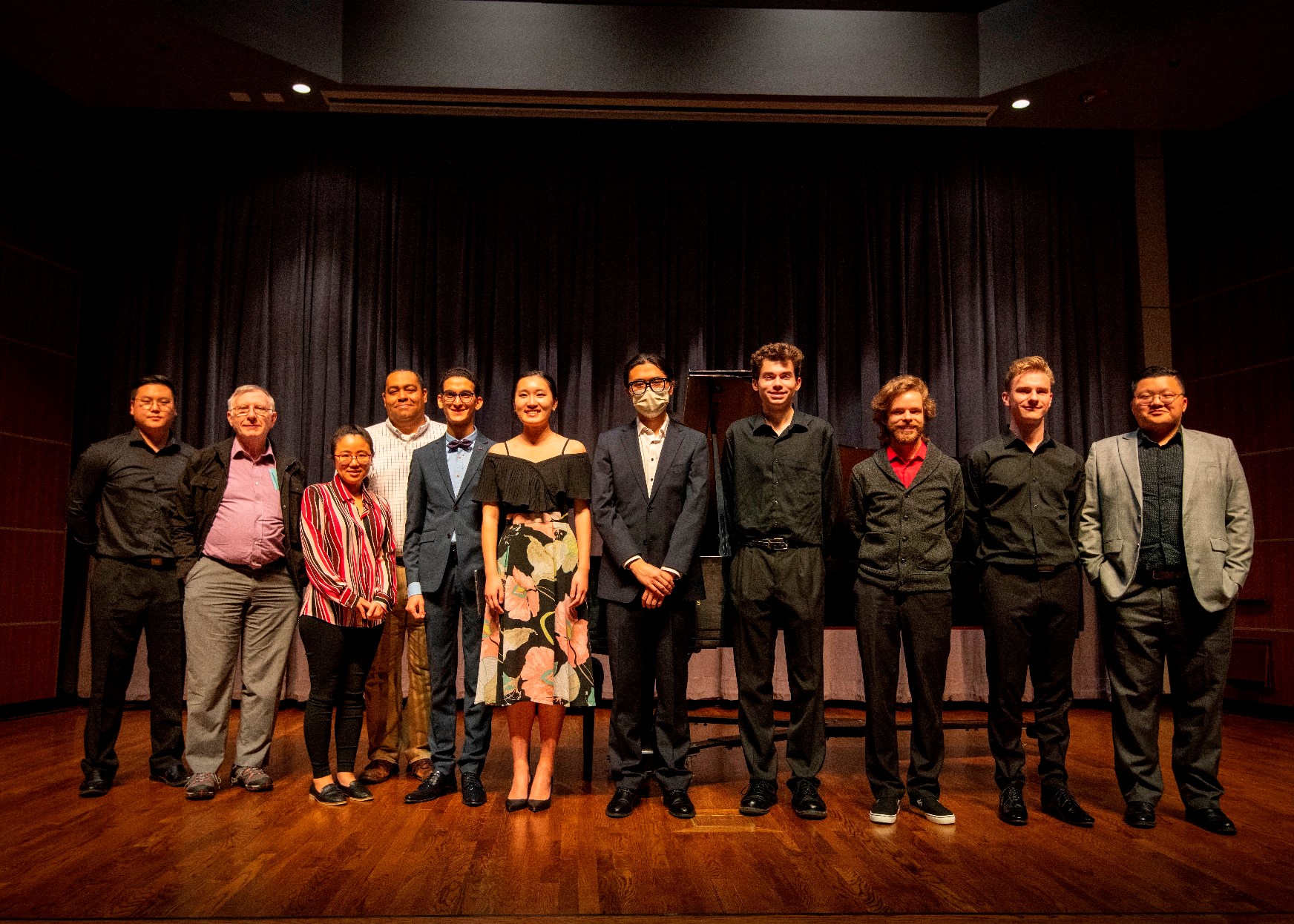 Students along with faculty members Ester Park and Daryl Carter on stage in front of a piano