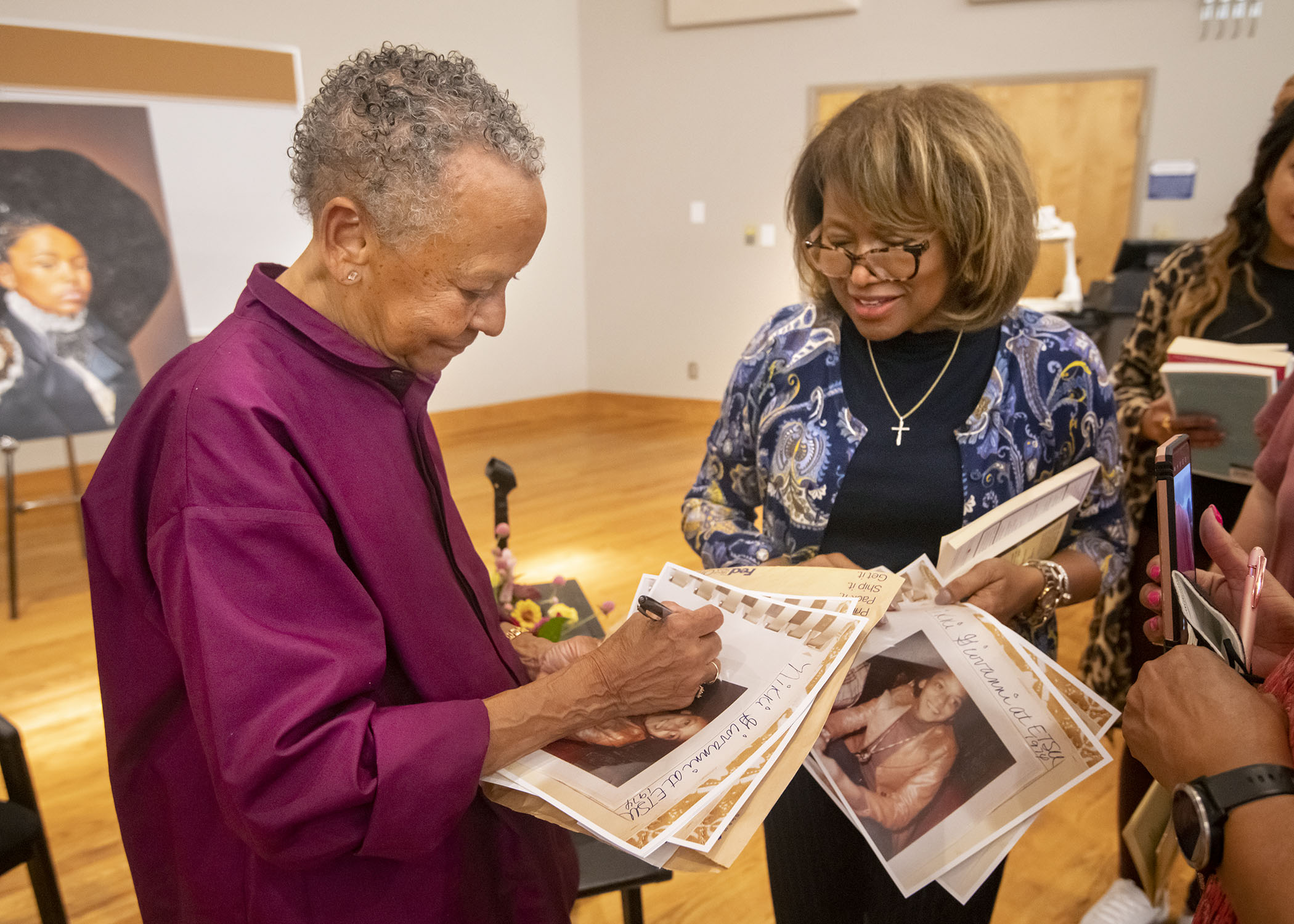 Nikki Giovanni signs photos from her 1974 visit to ETSU for Trustee Dorothy Grisham
