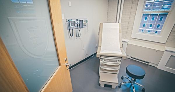 A patient suite in ETSU's Bishop Hall, featuring an exam table, exam equipment, and a rolling stool for the provider.