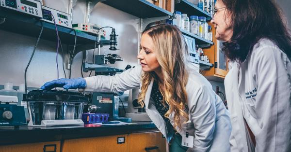 An ETSU Pharmacy student working in the compounding lab alongside her professor