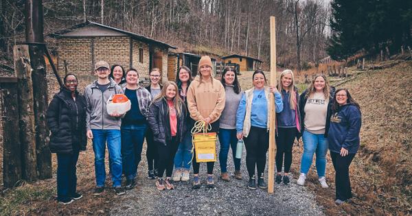 A group of ETSU students standing outside of the ETSU Eastman Valleybrook campus holding supplies they used for hands-on simulations