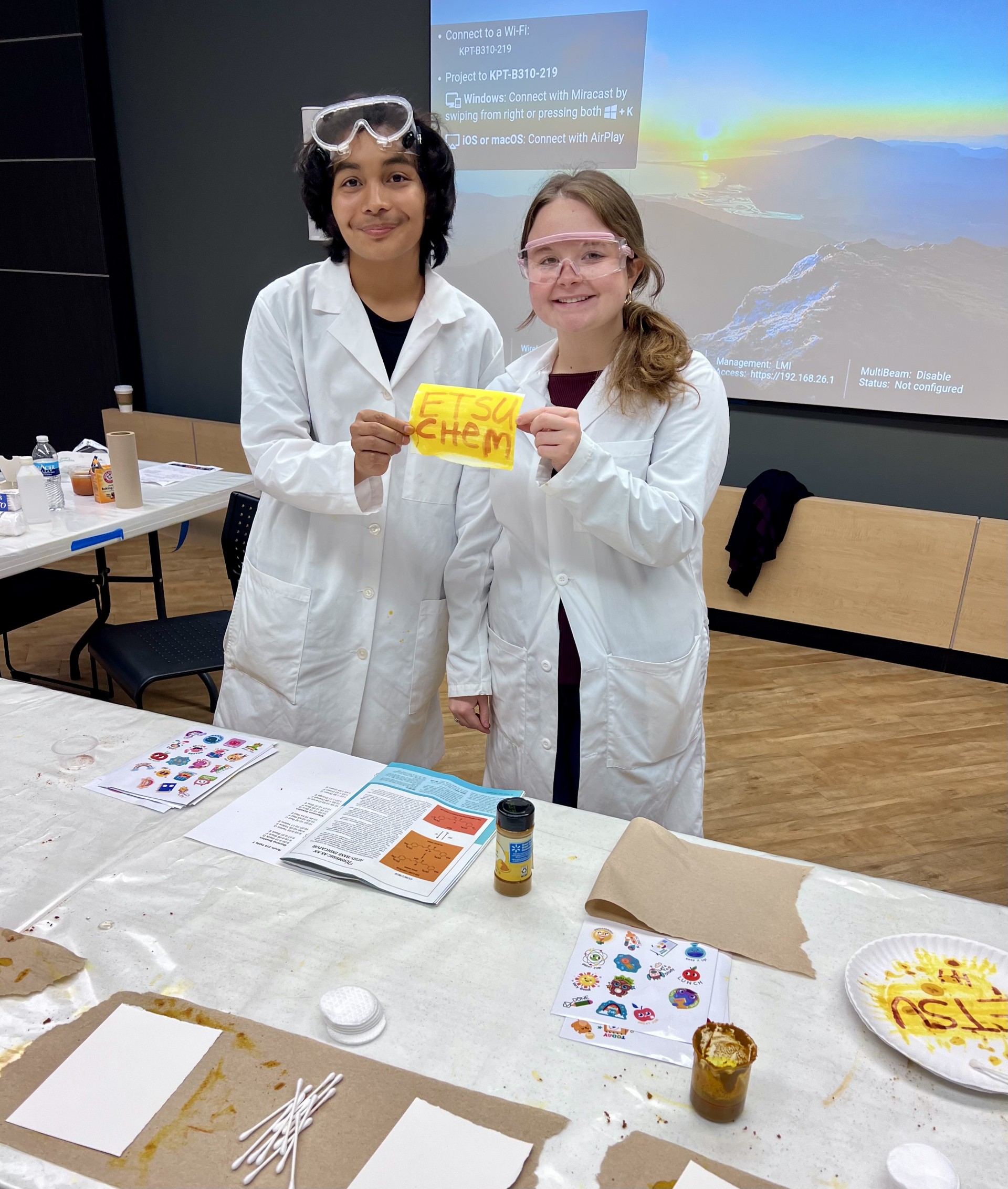 Two students at a table during the East NCW 2025 event. 