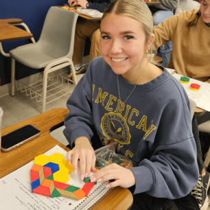 Students working with pattern blocks in primary education class.