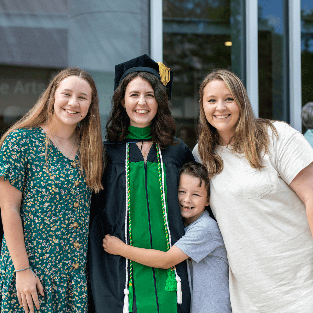 family pictured hugging the graduate