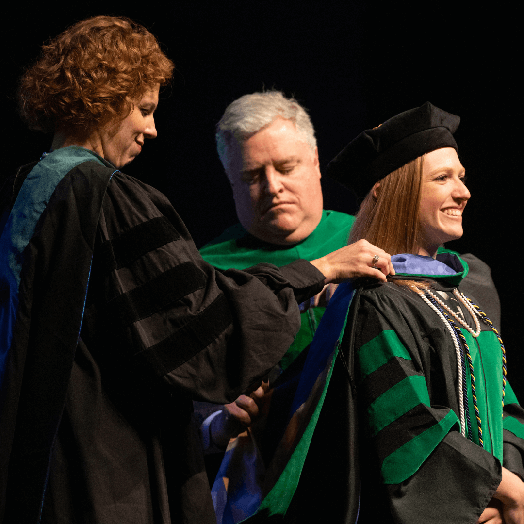 student getting hooded during the ceremony