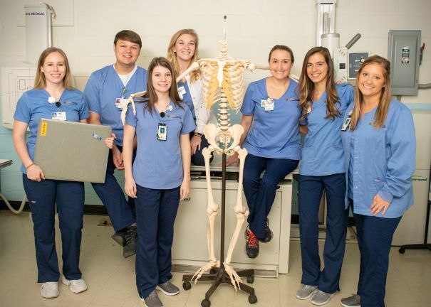 radiography students posing with skeleton