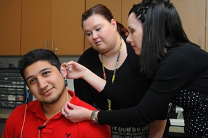 students with a patient in the hearing clinic