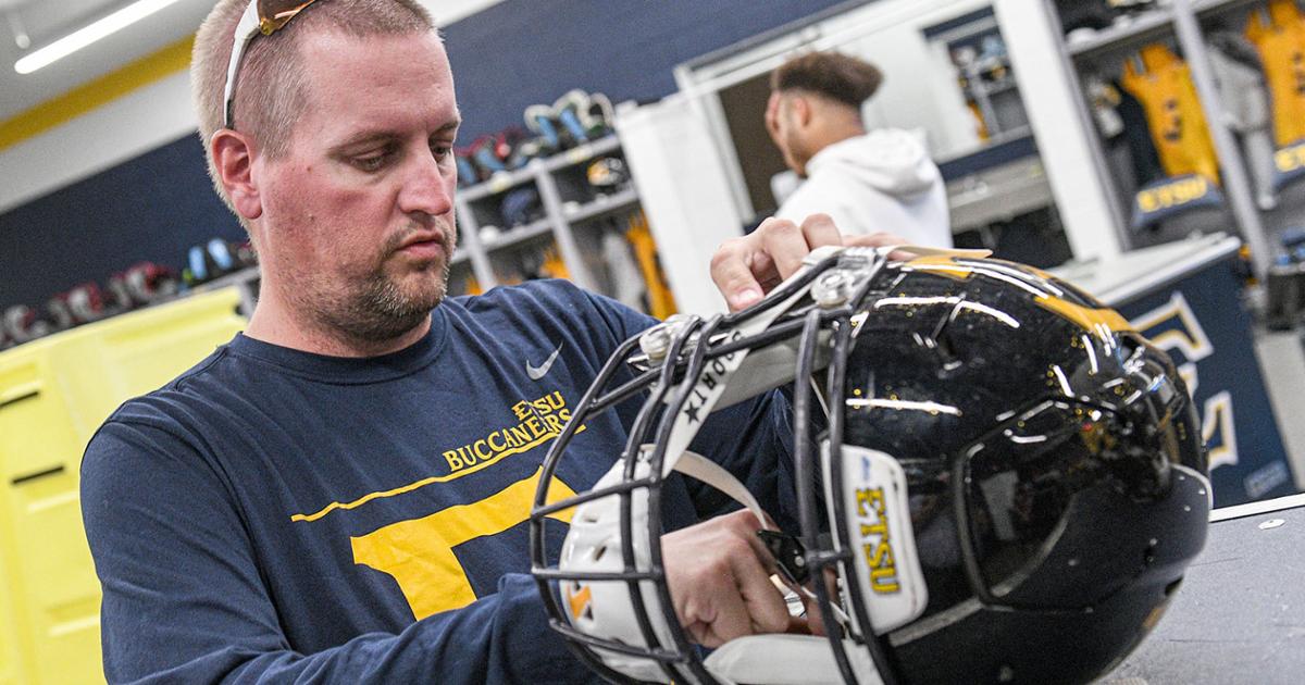 – Sam Rice makes adjustments to a player’s helmet in the locker room