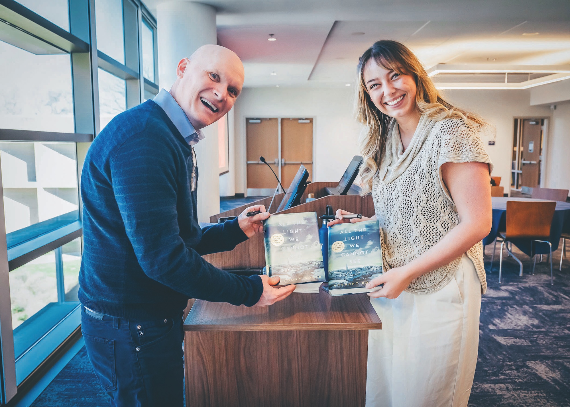 ETSU Festival of Ideas speaker Anthony Doerr holds a copy of the book All the Light We Cannot See while standing next to a student who is also holding a copy of the book.