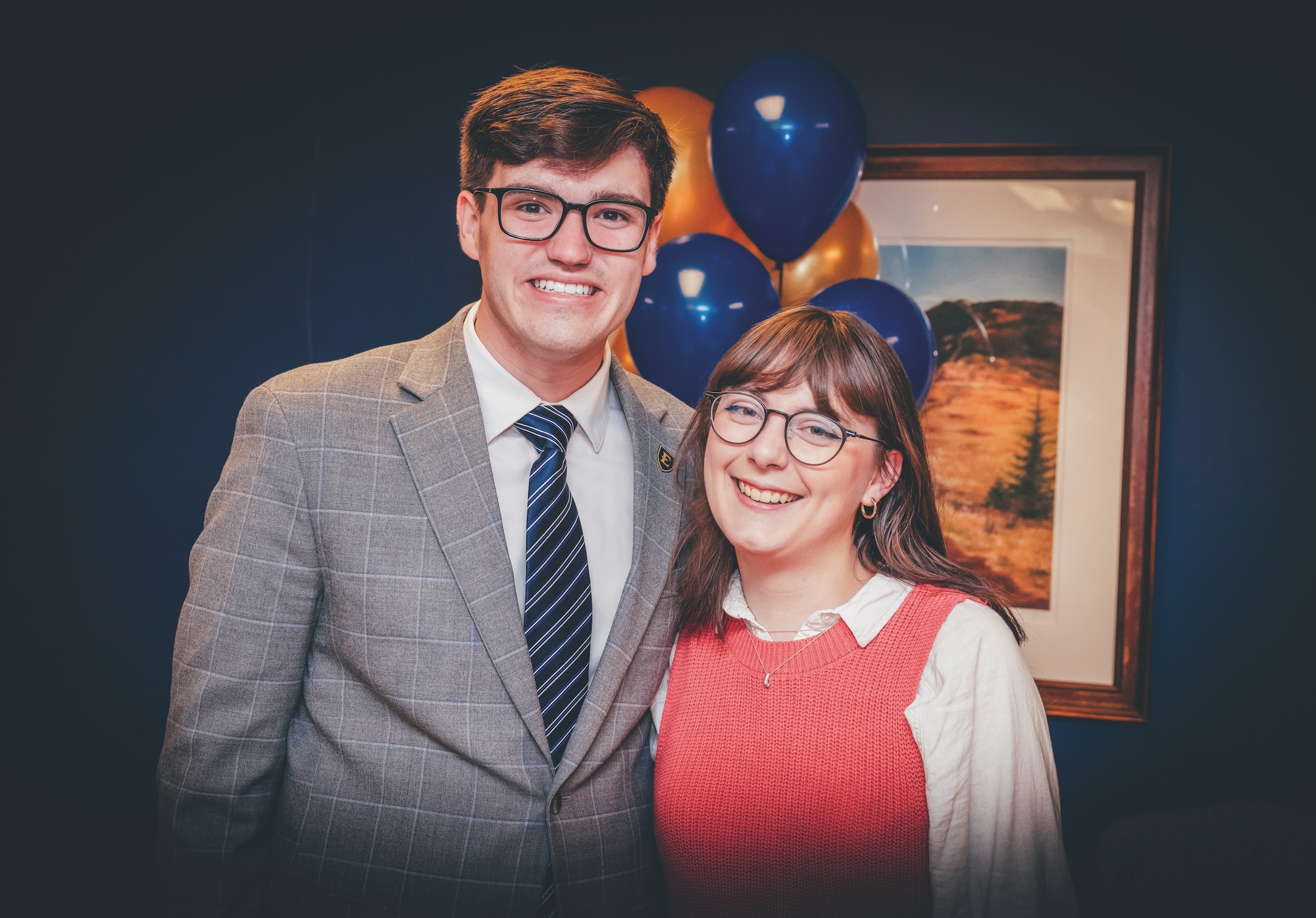 A presenter on staTrent White and Leah Loveday stand in front of balloons at a Truman Scholar celebration.ge at the 2024 Appalachian Highlands Economic Forum at the Martin Center for the Arts.