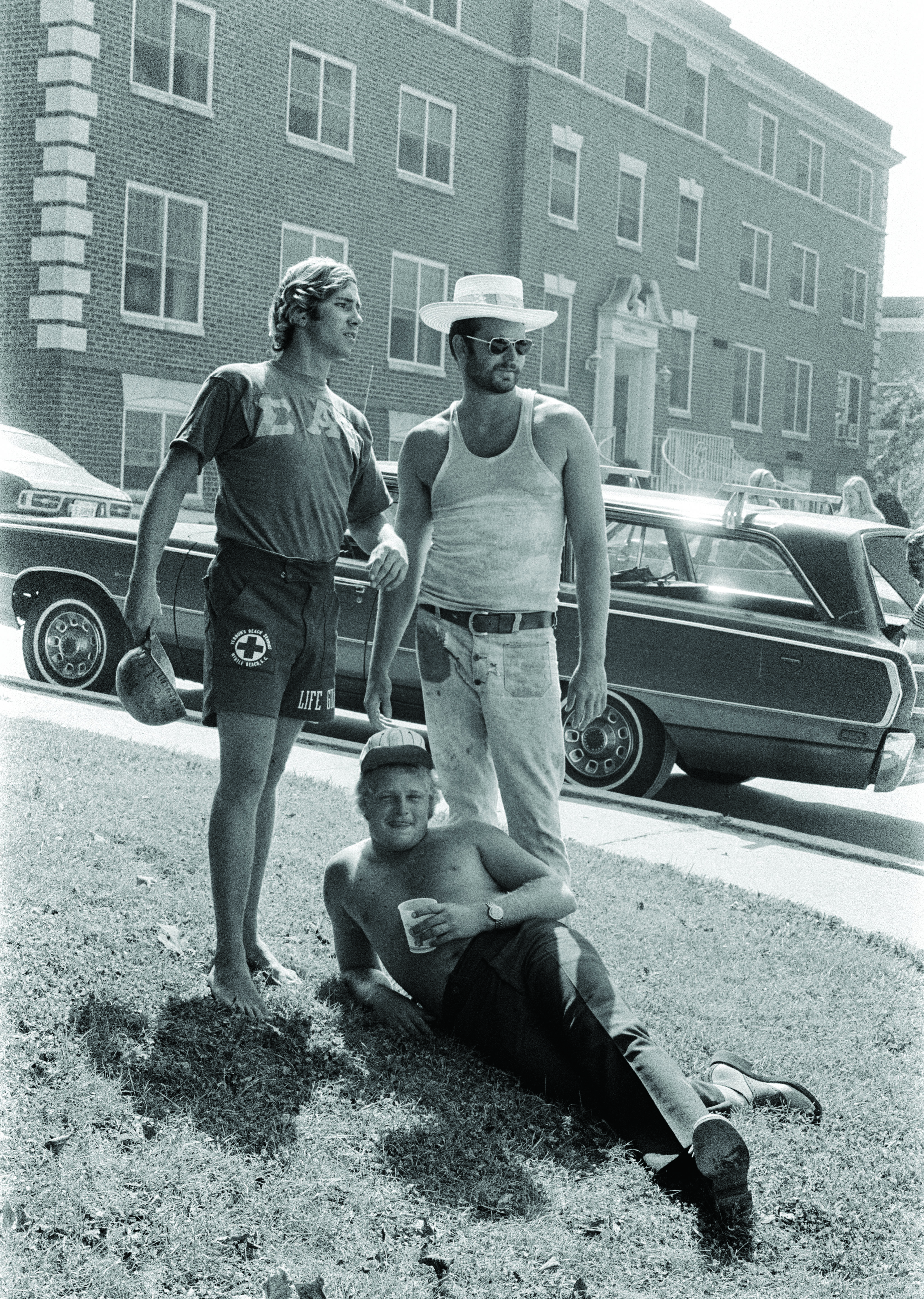 Three male ETSU students relax outside of a residence hall.