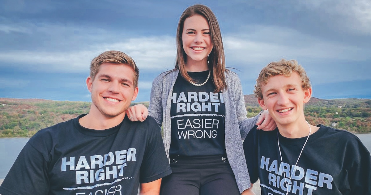 Three Roan Scholars wear T-shirts that say “Harder Right, Easier Wrong”