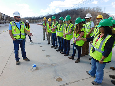 Geologist Nate Boles of Black & Veatch shows ETSU student visitors some of the hundreds of grout holes drilled at Boone Dam