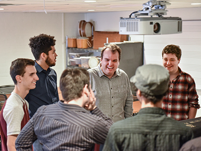 Shawn Salley (center) shares a lighthearted moment with The Swashbucklers in rehearsal.