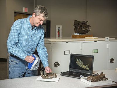 Dr. Chris Widga, head curator at the ETSU Museum of Natural History at the Gray Fossil Site, scans a fossil peccary jaw to create a 3D digital model