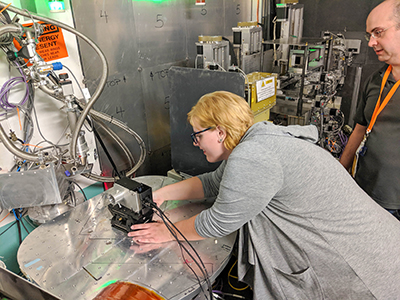 Summer Undergraduate Laboratory Intern Taylor Dennis from East Tennessee State University and graduate student Shaun Vavra from University of Tennessee Knoxville prepare a neutron camera at the Magnetism Reflectometer at the Spallation Neutron Source at Oak Ridge National Laboratory.   This instrument was used to perform a search for hypothetical neutron oscillations into a dark matter candidate. (Photo contributed by Taylor Dennis and Oak Ridge National Laboratory)