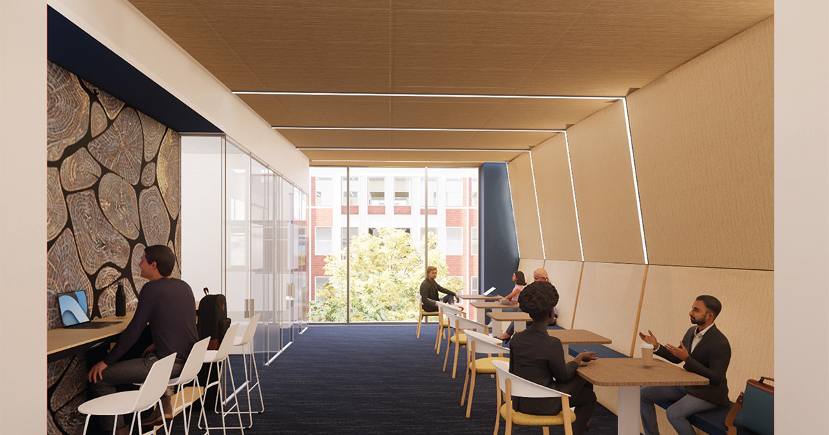 Rendering of a study lounge in the renovated Brown Hall at ETSU featuring wood-paneled walls, café tables, and a row of computer workstations along a textured accent wall. Students meet in small groups and work individually near large windows overlooking campus.