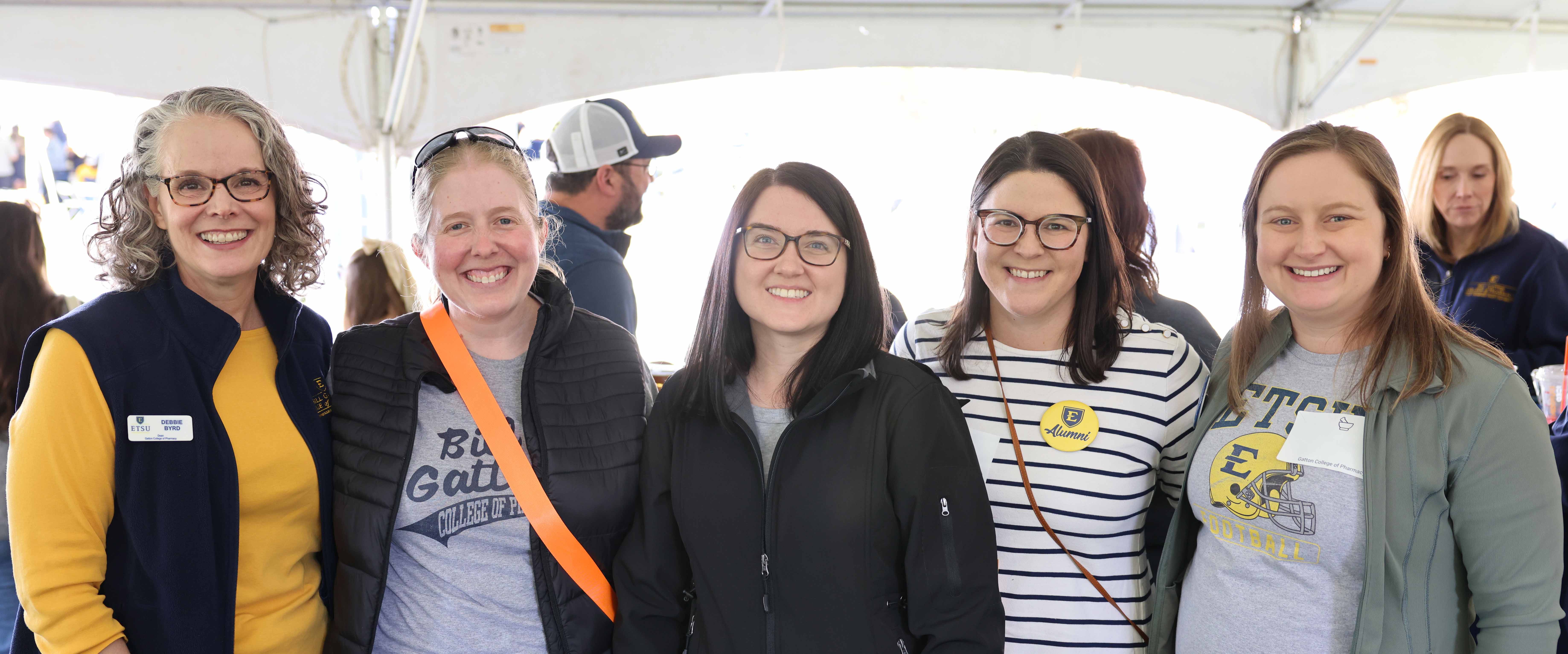 Group standing under tent