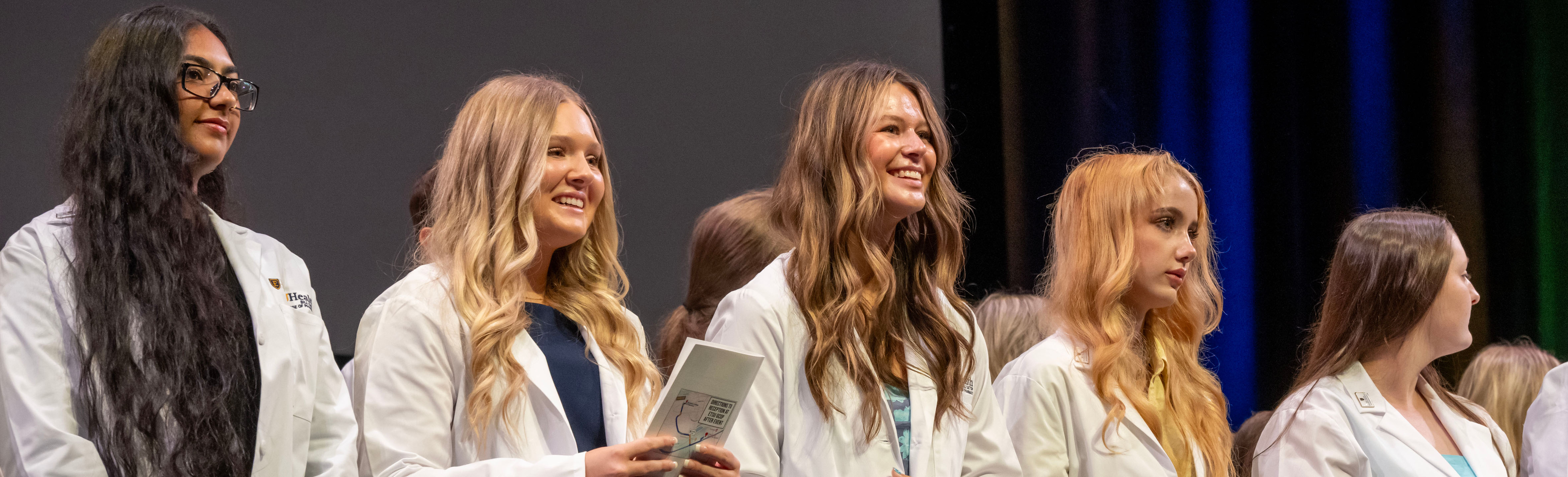 Female students smiling at White Coat Ceremony